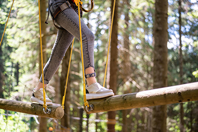 escapada-aventura chica haciendo deporte de aventura en los arboles